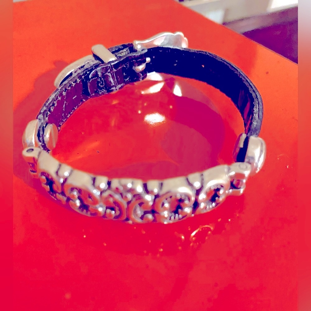 Silver buckle leather bracelet with detailed silver accents.